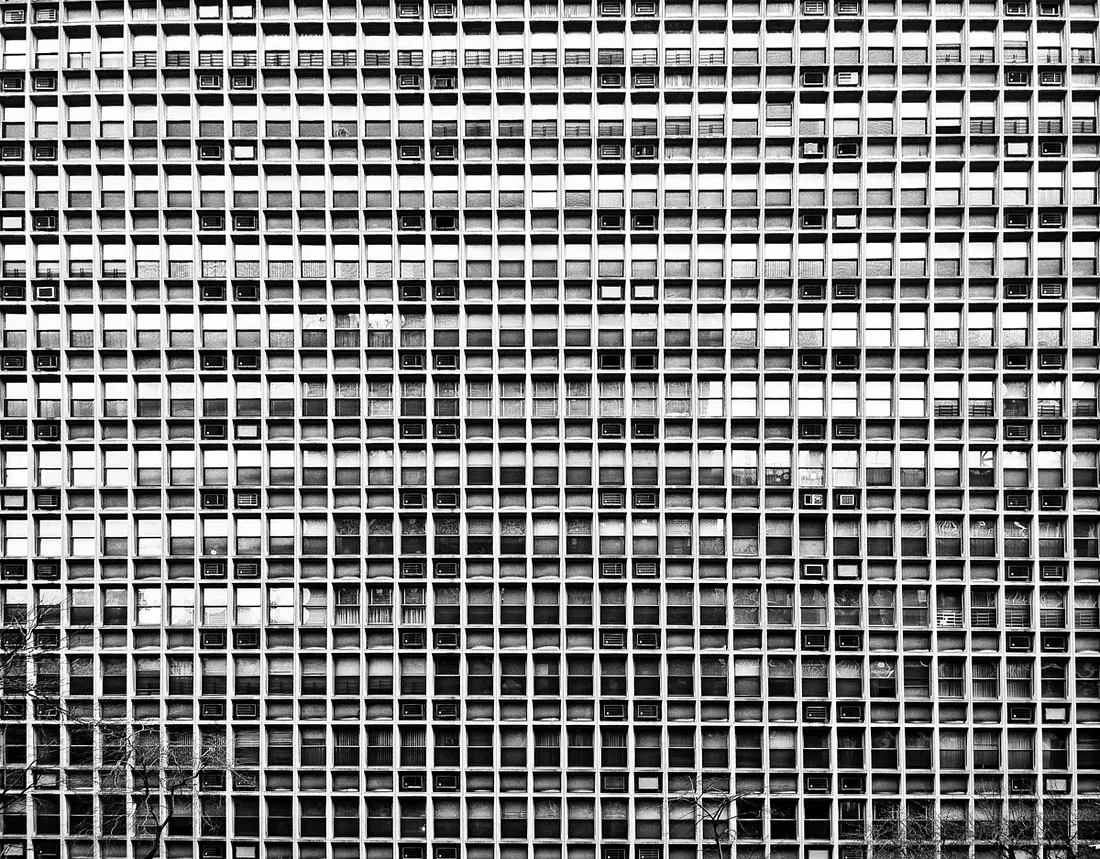 black and white image of many small windows in an apartment building